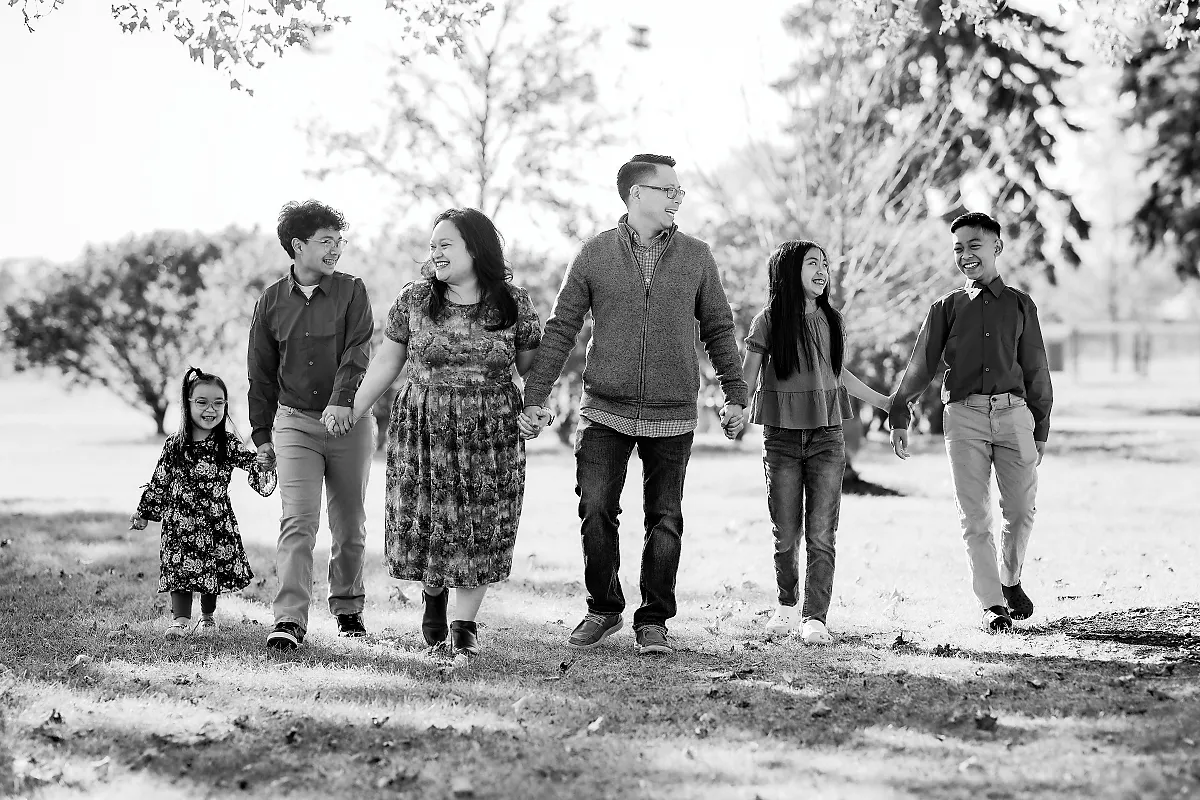 Black and white family portrait walking together outdoors holding hands