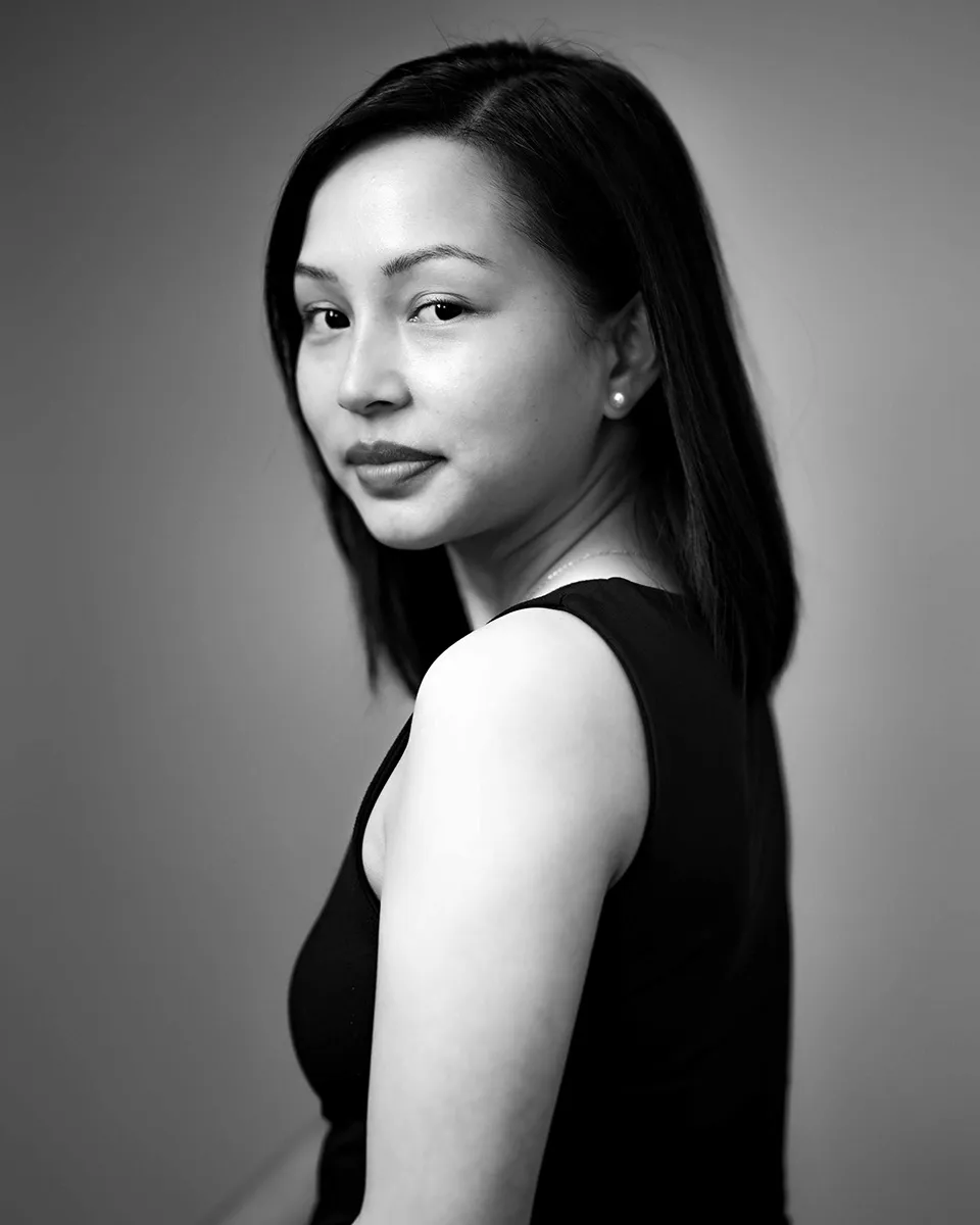 Black and white headshot of a woman looking back over her shoulder