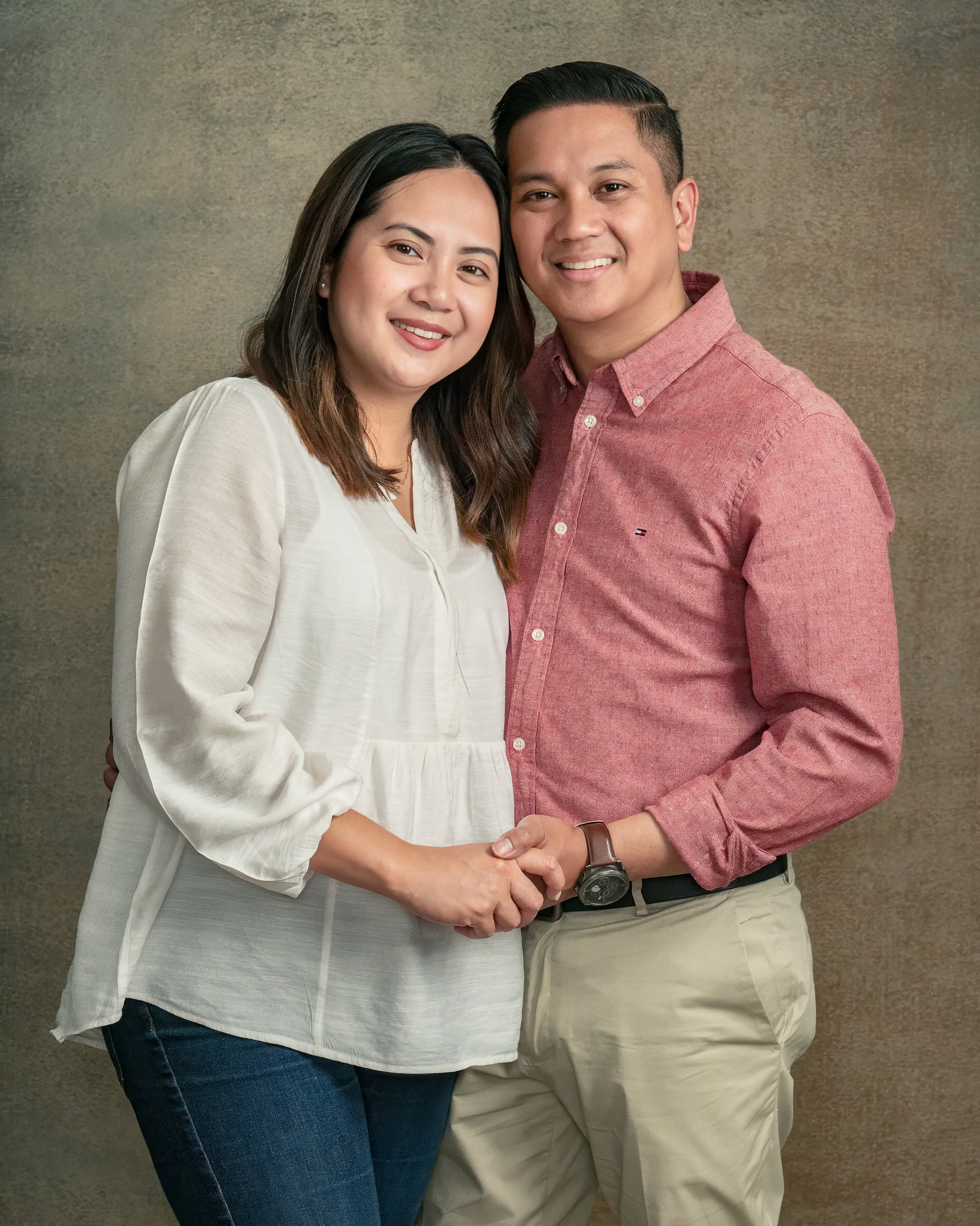Couple holding hands together in a studio portrait