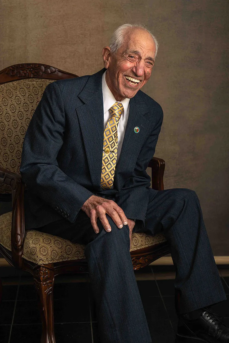 Older man laughing in a suit and patterned tie for a studio portrait